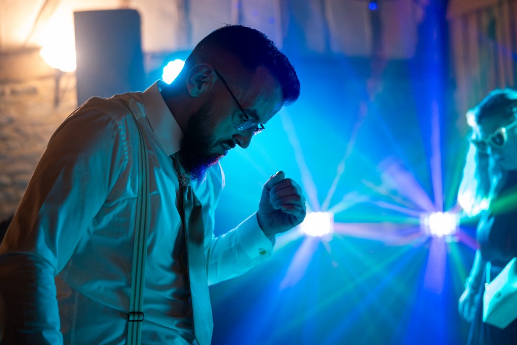 Invité dansant sous les projecteurs pendant une soirée de mariage
